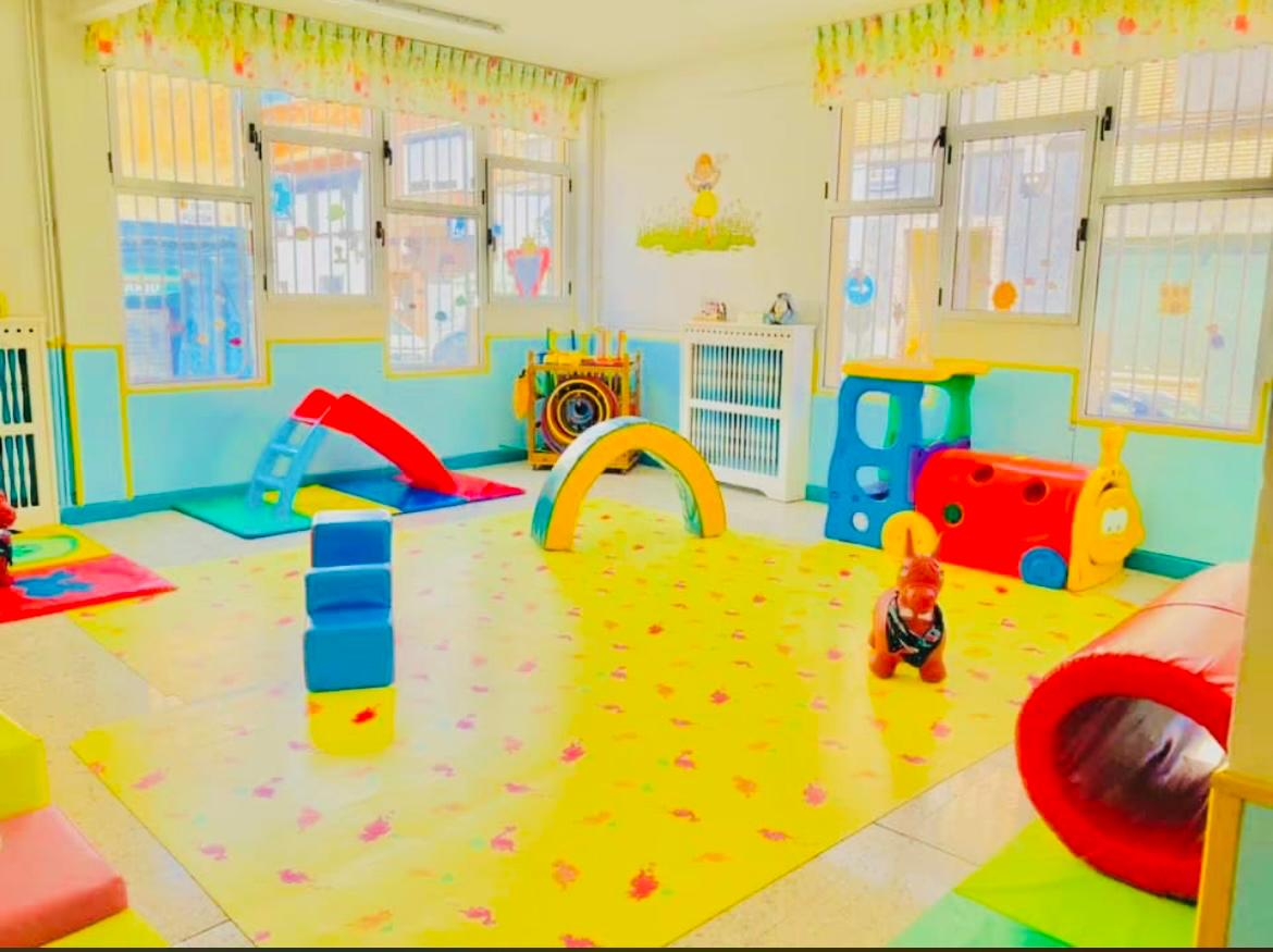 Aula de juegos con alfombra, toboganes y juguetes