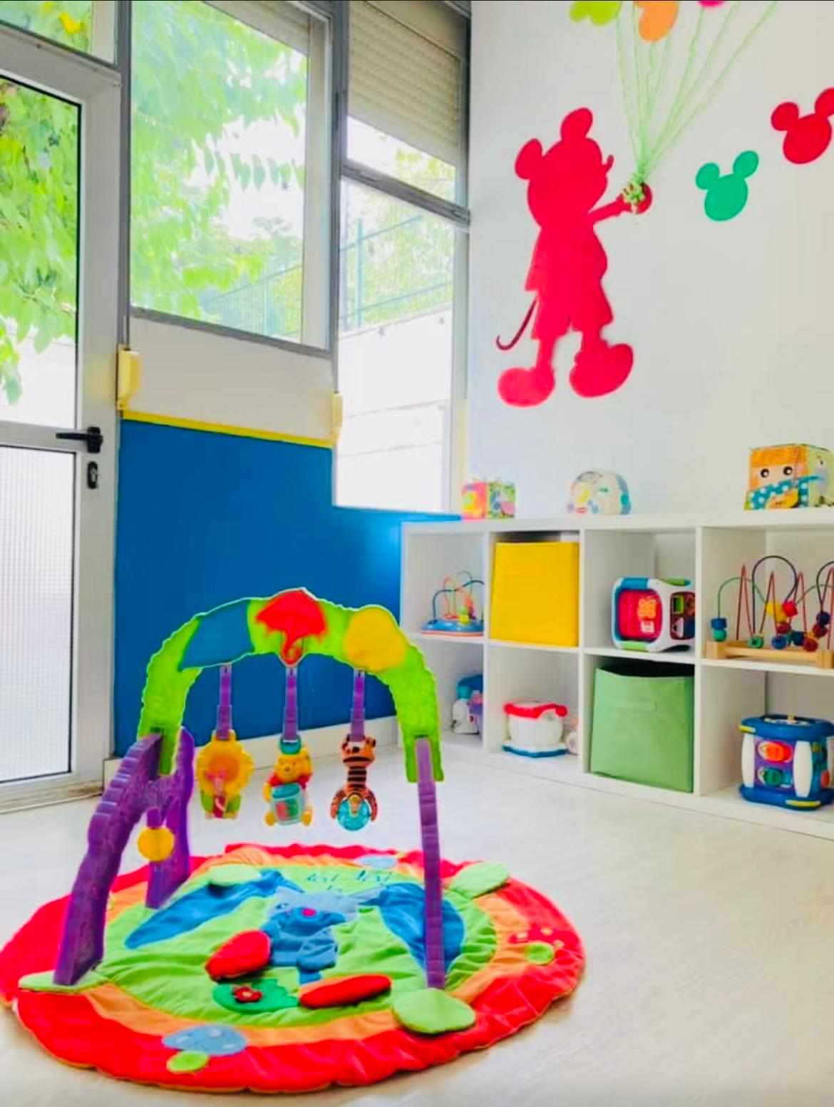 Aula con manta de actividades y zona de estimulación para bebés