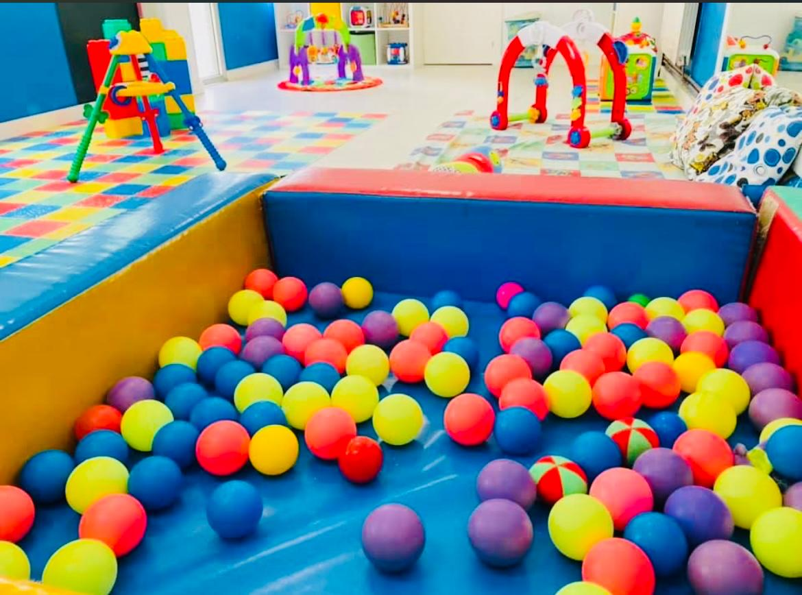 Piscina de bolas de colores con juguetes alrededor